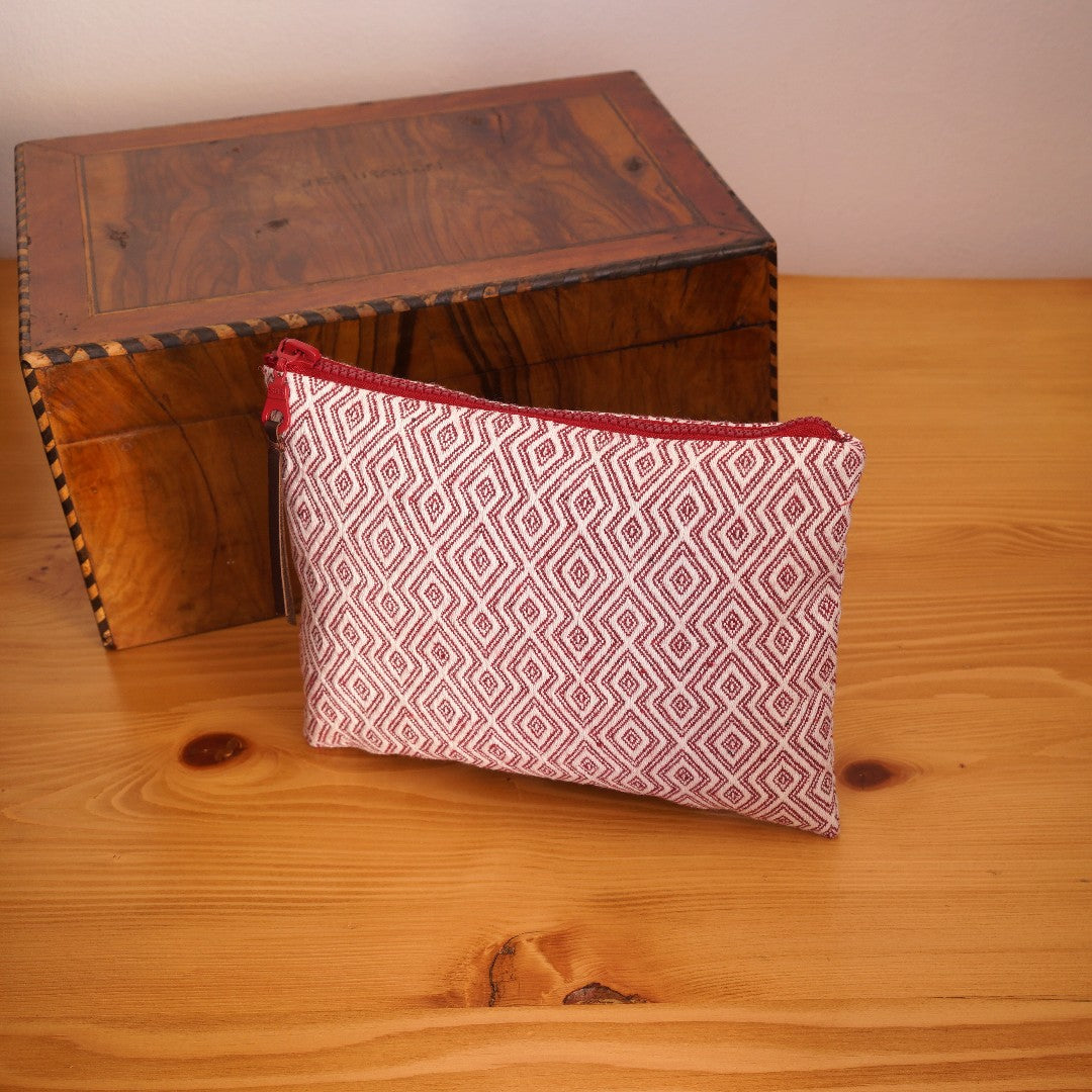 Aeolia Handwoven Makeup Bag, clutch cosmetic bag angled with a decor box