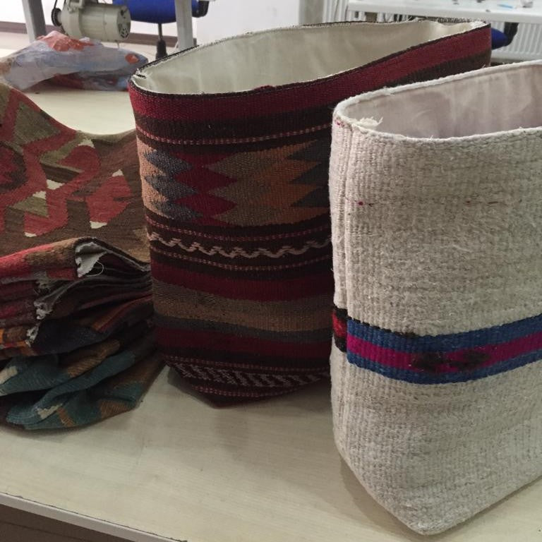 product page bulletin image, unfinished bags on a table in an atelier